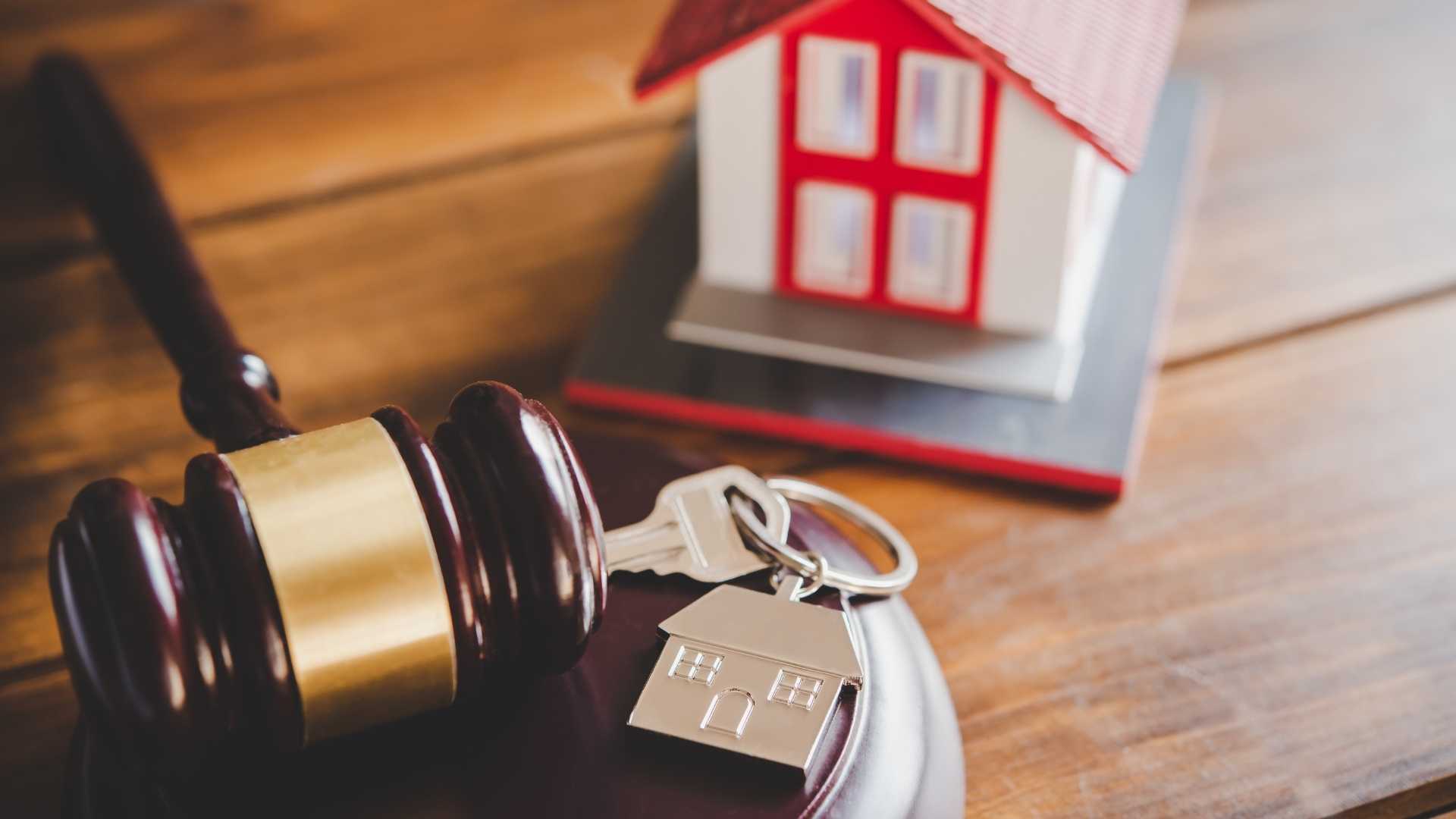 a gavel and house figurine