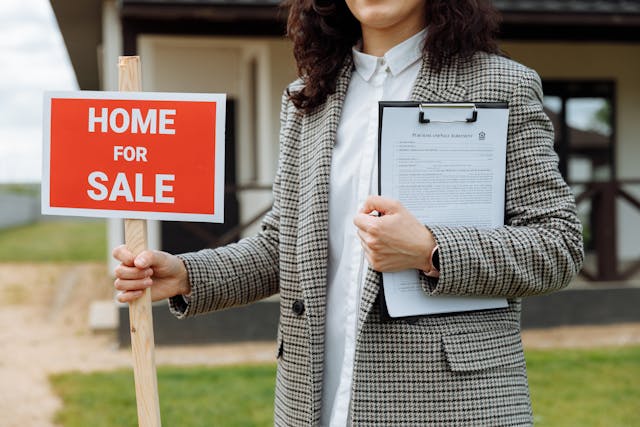 an agent holding a for sale sign